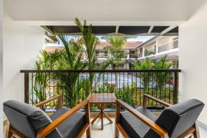 a balcony with chairs and a view of a building at Mango Hill Hotel Velankanni in Velankanni