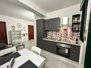 a kitchen with black cabinets and a table in a room at Casa Jaya Taormina in Taormina