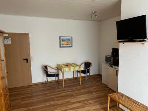 a room with a table and two chairs and a television at Ferienhof Schäfer in Oberderdingen