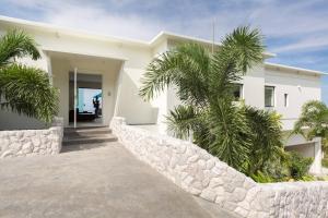 a white house with palm trees in front of it at Villa Danisa 4BR Panoramic Ocean View with Infinity Pool & Private Gym in Choeng Mon Beach