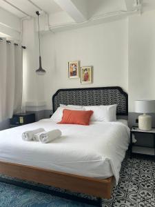 a bedroom with a large bed with white sheets and red pillows at Chinoir Boutique Phuket Town in Phuket +26 photos