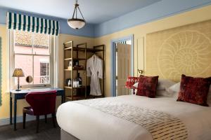 a bedroom with a bed and a desk and a window at The Bull Hotel in Bridport +103 photos