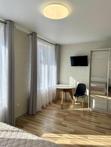 a bedroom with a table and a chair and a bed at Апартаменти Пасаж 2 in Skhidnitsa