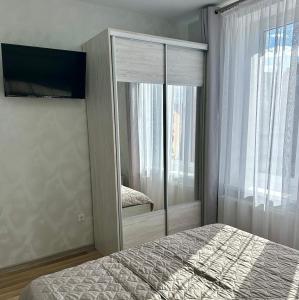 a bedroom with a bed and a large mirror at Апартаменти Пасаж 2 in Skhidnitsa