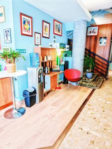 a living room with blue walls and a red chair at ibis Styles Le Havre Centre in Le Havre