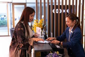 two women standing next to a table with a laptop at Grand Kingsgate Jaddaf Waterfront Hotel by Millennium in Dubai +53 photos