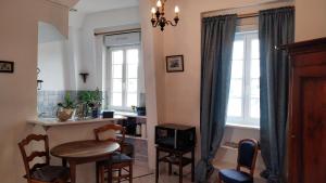 a kitchen with a table and chairs and a window at Studio De La Mer in Arromanches-les-Bains