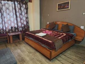 a bedroom with a wooden bed in a room at Hotel Shree Ram in Shimla