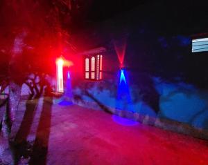 a house lit up with red and blue lights at Rd resort in Jāmb