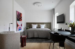 a bedroom with a bed and a desk with a computer at Aggersvold Gods in Jyderup