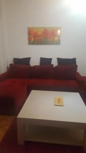 ブカレストにあるHospitality Centrum - Nicolae Iorgaのリビングルーム(赤いソファ、テーブル付)