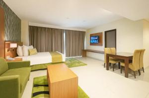 a hotel room with a bed and a desk at Ijen Suites Resort & Convention in Malang