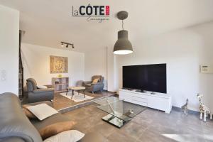 a living room with a couch and a flat screen tv at Villa Laterra in Ensuès-la-Redonne