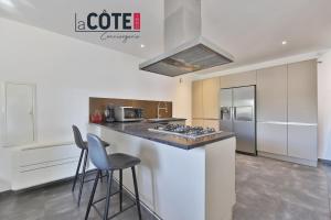 a kitchen with a counter with stools and a stove at Villa Laterra in Ensuès-la-Redonne