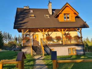 a house with a porch with flowers on it at Chata Wielki Potok in Istebna