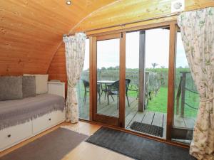 a bedroom with a bed and a balcony with a table at Grape Escape in Halesworth +7 photos