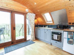 a kitchen with wooden ceilings and a large window at Grape Escape in Halesworth