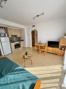 a living room with a table and a kitchen at Apartament Deportiva in Deltebre