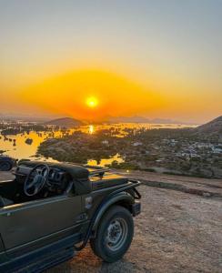 a truck parked on top of a hill with the sunset at Chandras palace hotel kothar in Kothār