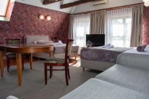 a hotel room with a bedroom with two beds and a desk at Heban Hotel in Toruń