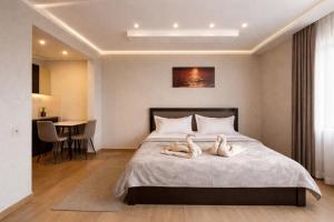 two swans laying on a bed in a bedroom at Villa Caza in Chişinău +35 photos
