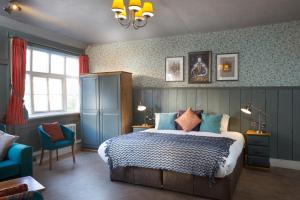 um quarto com uma cama e uma parede azul em The Ostrich Inn Colnbrook London Heathrow em Slough