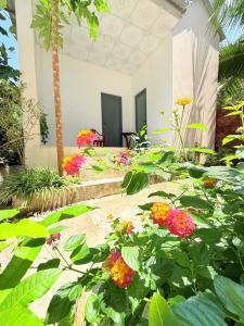 a garden with flowers in front of a house at Ocean Bungalow in Phú Quốc +9 photos