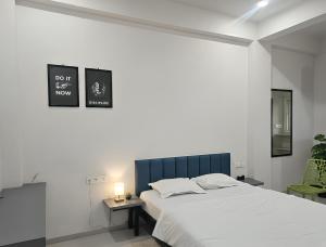 a bedroom with a large bed with a blue headboard at Hotel Blueberry Bhedaghat in Jabalpur