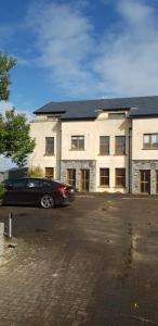 a car parked in front of a large building at Surfers Getaway - Room Staycation in Sligo