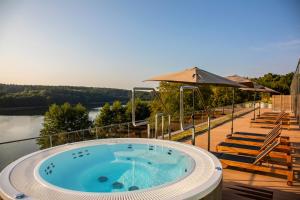 a hot tub on a deck with a view of a river at Hotel GLAR Conference & SPA in Wisełka
