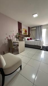 a bedroom with a bed and a table and a chair at Flat JK 103 in Juazeiro do Norte