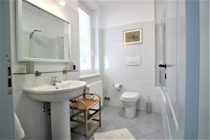 a white bathroom with a sink and a toilet at Holiday Home Lake Orta in Pettenasco +127 photos