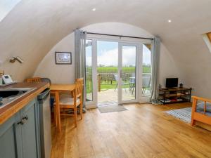a kitchen with a table and a view of a patio at Vine View in Halesworth