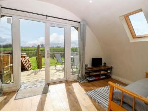 a living room with a sliding glass door to a patio at Vine View in Halesworth