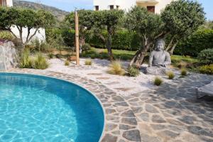 a large statue next to a pool with aitatingitatingitatingitatingitatingitatingitating at Paralia Apts Stavros in Milatos +38 photos