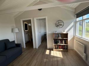 a living room with a couch and a book shelf at Mountain Cabin at Rauðafell in Hvolsvöllur
