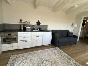 a kitchen with a couch and a stove at Mountain Cabin at Rauðafell in Hvolsvöllur