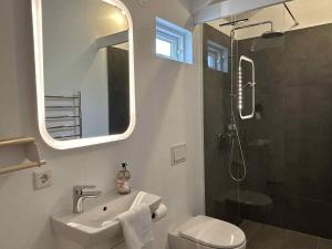 a bathroom with a sink and a shower with a mirror at Mountain Cabin at Rauðafell in Hvolsvöllur +8 photos