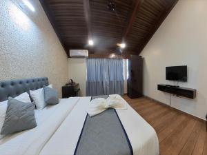a large bed with a bow on it in a room at M Beach Resort in Colva