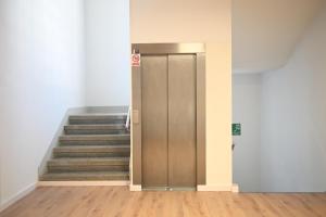 a metal elevator in a building with stairs at A Casa da Toura in Puentedeume