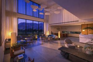 a lobby with tables and chairs and a large window at Avisa Hotel & Resort Abu Road - Luxury Pool & Mountain View in Ābu Road