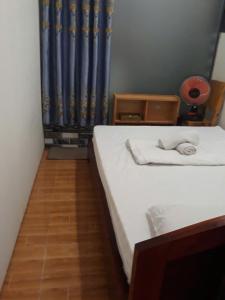 a bedroom with a white bed and a blue curtain at Homestay846 in Vung Tau