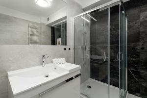 a bathroom with a sink and a shower at Sunset Resort Jasny Apartament z 1 Sypialnią 500 m od Plaży, Balkon & Parking by Noclegi Renters in Grzybowo