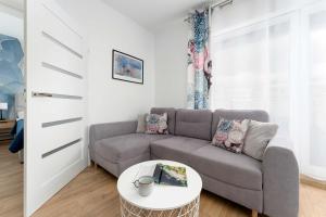 a living room with a couch and a table at Sunset Resort Jasny Apartament z 1 Sypialnią 500 m od Plaży, Balkon & Parking by Noclegi Renters in Grzybowo +25 photos