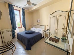 a bedroom with a bed and a desk with a laptop at Hotel Primula in Alassio