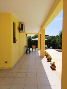 a patio with yellow walls and tables and chairs at TeNuTa Li Frasulli in Sannicola +10 photos