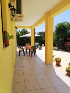 a patio with chairs and a table on a house at TeNuTa Li Frasulli in Sannicola