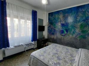 a bedroom with a bed and a painting on the wall at Villa La Lanterna in Pietra Ligure