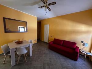 a living room with a red couch and a table at Casa Gio in Lesa