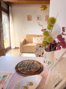 a living room with a table with a vase of flowers at Gästezimmer Ferienhaus Waldblick in Sonnenbühl